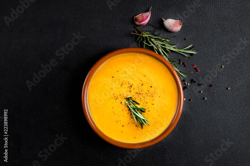 Pumpkin and carrot  Cream soup on  black board  background. Autumn cream-soup in country style. Top view. Copy space. photo