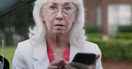 A retiree launching a second career as an Uber or Lyft driver checks the mobile app then greets her passenger and engages in friendly conversation before starting the ride. photo