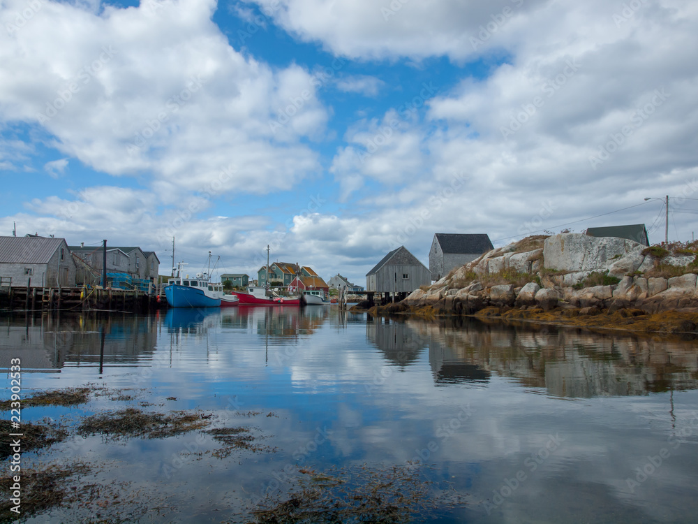 Peggy's Cove Harbour with boats at low tide, summer, clouds in blue sky, peaceful Peggy's Cove Harbour with boats at low tide, summer, clouds in blue sky, peaceful