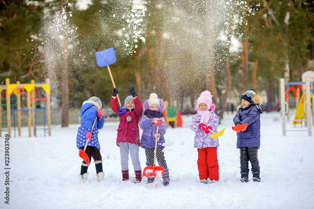 cheerful friends play in a winter park, throw snow and have fun
