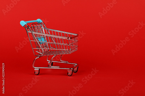 Close up retail shopping cart on red background