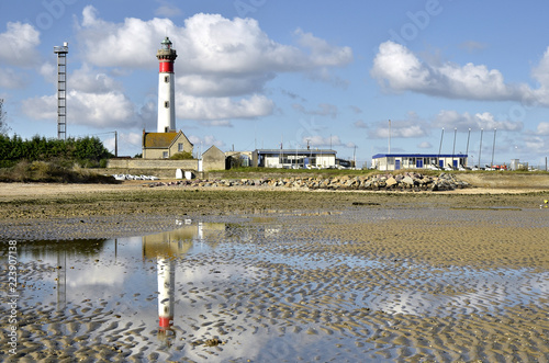 Ligthouse with reflection on the sand of the beach at low tide at Ouistreham , commune in the Calvados department in the Basse-Normandie region in northwestern France. photo