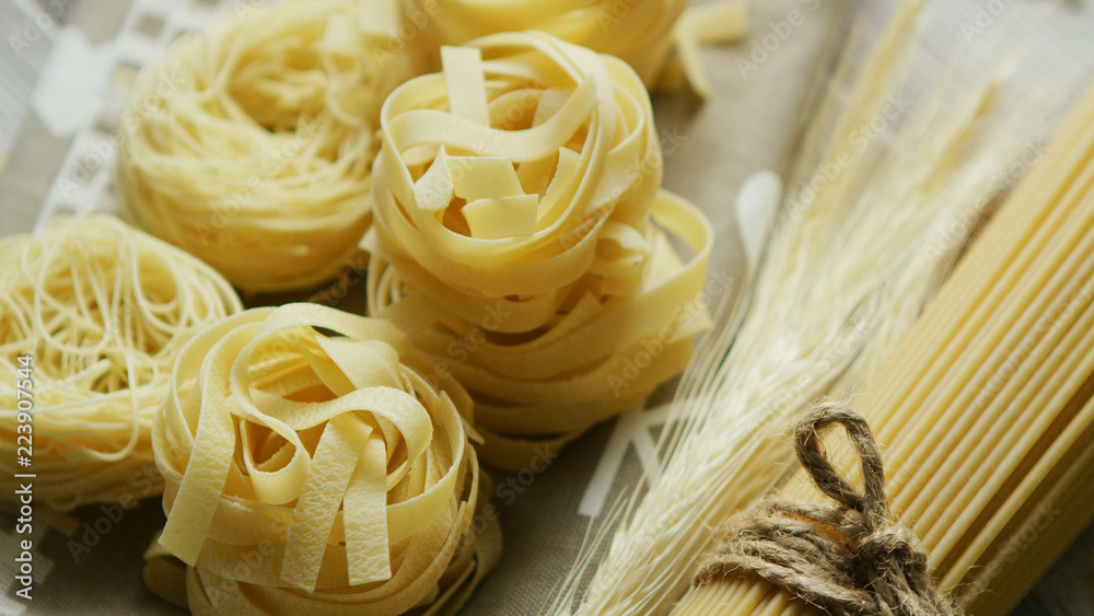 From above view of spaghetti rolled in balls with raw macaroni laid near and tied with rope From above view of spaghetti rolled in balls with raw macaroni laid near and tied with rope