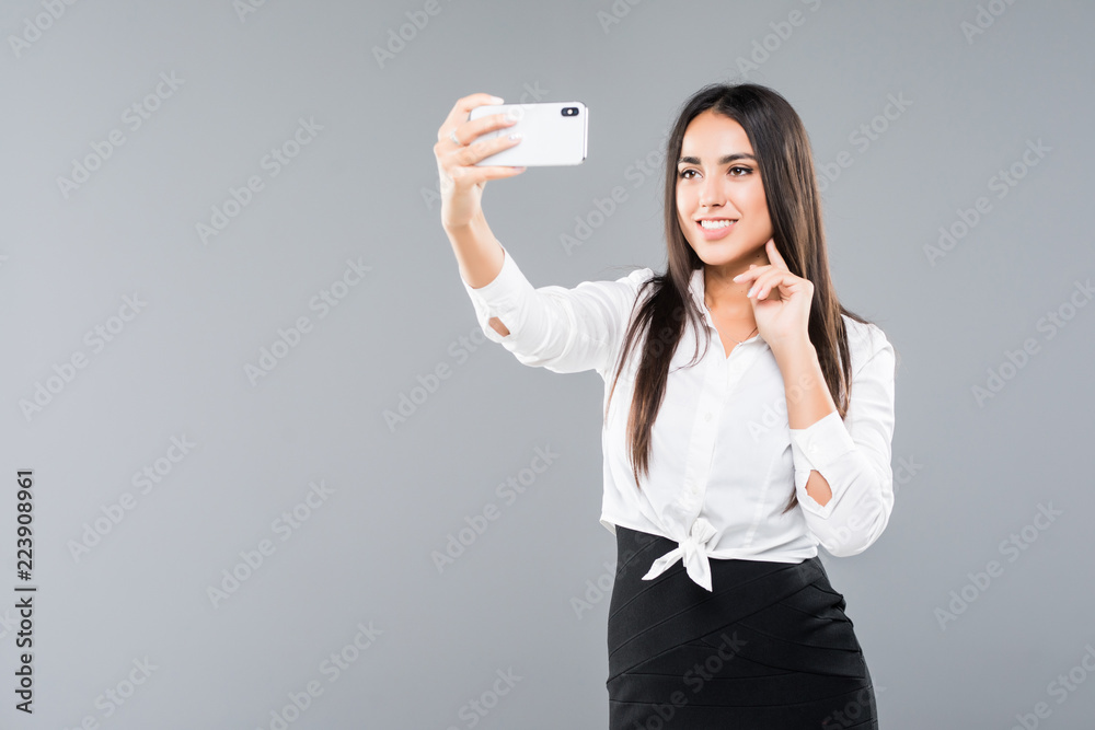 Happy businesswoman making selfie photo on smartphone or making video call over white background Happy businesswoman making selfie photo on smartphone or making video call over white background
