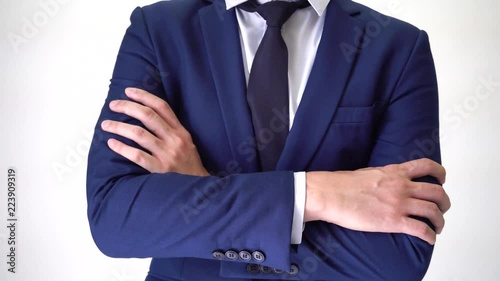 Confident business man walking into focus area and having arms crossed on white background photo