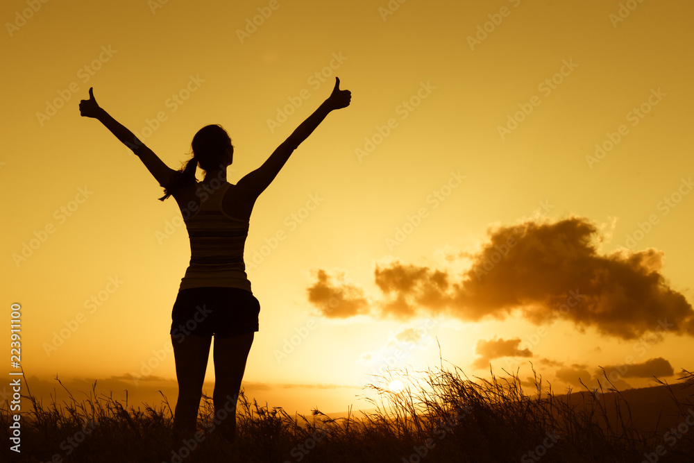 Feeling positive. Happy female out doors at sunset with thumbs up. Feeling positive. Happy female out doors at sunset with thumbs up.