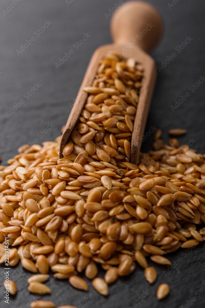 seeds of golden flax on a dark stone background seeds of golden flax on a dark stone background
