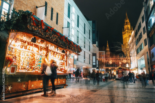 Blurred moved people and sales booth at the christmas market on Marienplatz against Town Hall Neues Rathaus in Munich, Germany photo