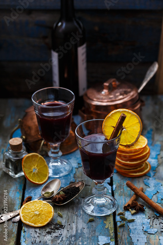 Two glasses of mulled wine with spices and orange slices, rustic style copy space