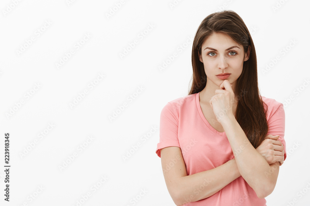 Girl stares with disbelief, hearing lies from boyfriend. Portrait of intense thoughtful and smart european woman with brown hair, staring at camera while touching chin, being doubtful Girl stares with disbelief, hearing lies from boyfriend. Portrait of intense thoughtful and smart european woman with brown hair, staring at camera while touching chin, being doubtful