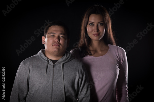studio portrait of a guy and a girl on a black background © serikbaib