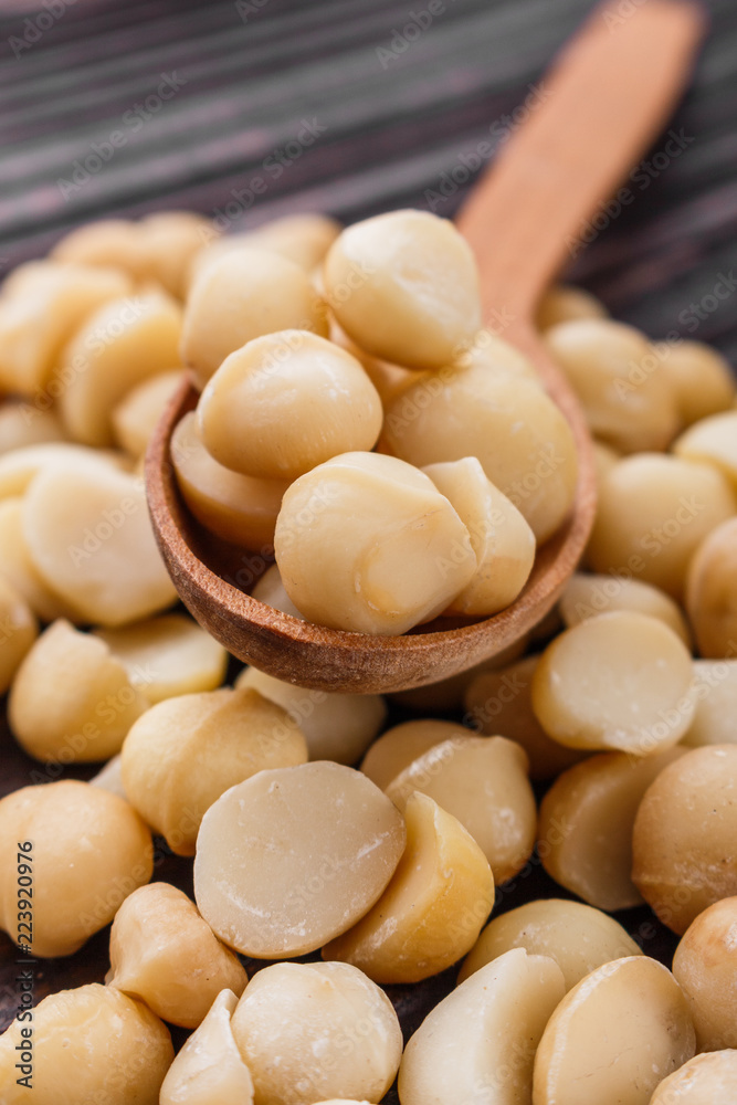 delicious macadamia nuts on a wooden rustic background delicious macadamia nuts on a wooden rustic background