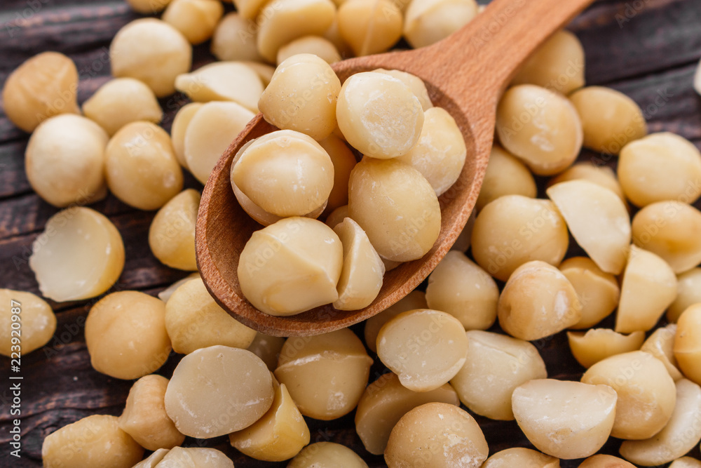 delicious macadamia nuts on a wooden rustic background delicious macadamia nuts on a wooden rustic background