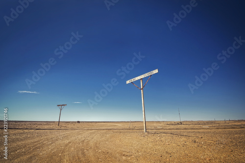 Australia – Old Ghan railway crossing at the outback desert under blue sky photo