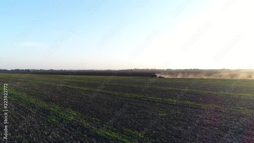 The tractor in the field plows the earth. Agriculture, aerial photography. The tractor in the field plows the earth. Agriculture, aerial photography.