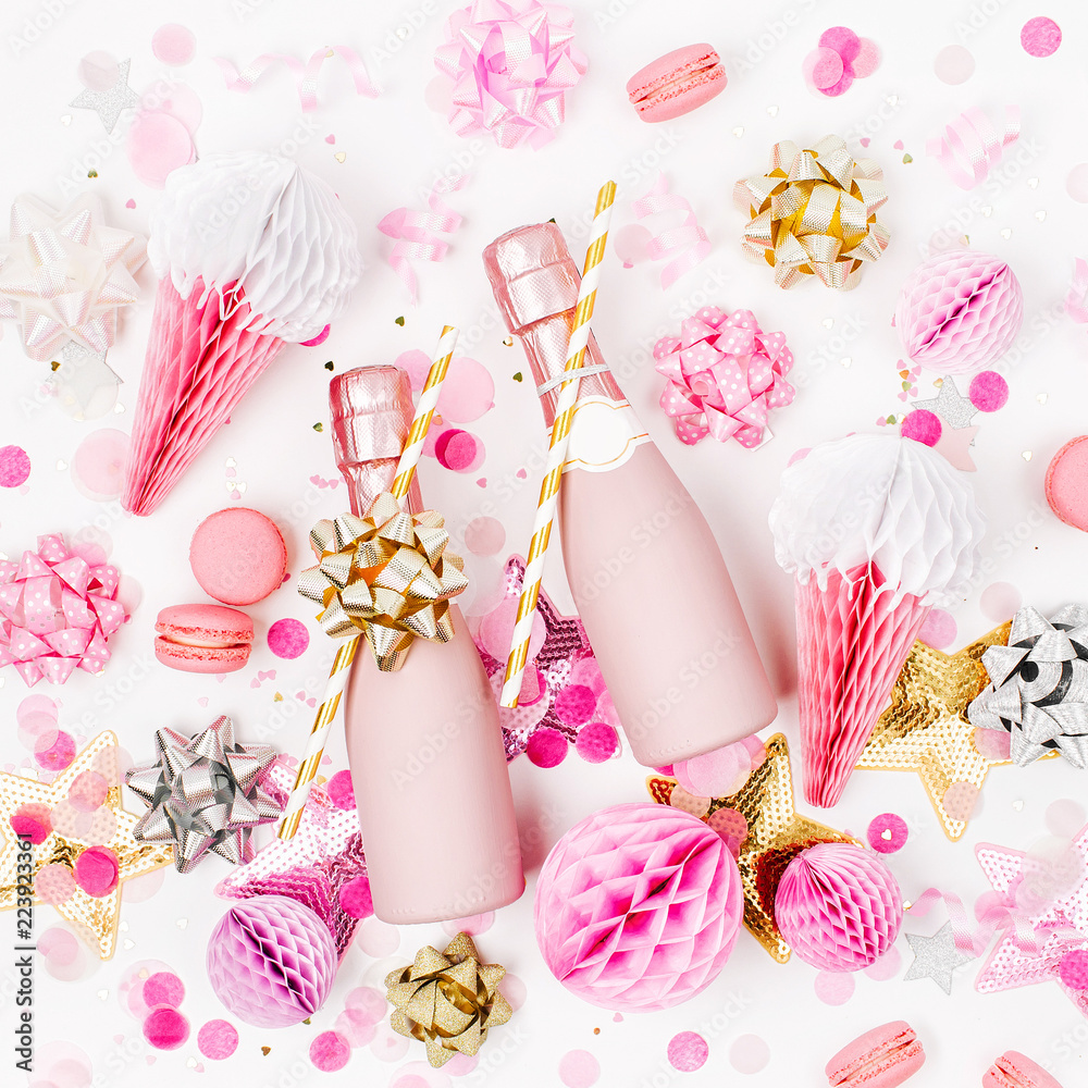 Pale Pink Mini bottles of champagne with confetti, tinsel and paper decoration. Flat lay, top view. New year/Christmas celebration or wedding  concept theme. Flat lay, top view