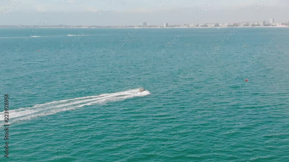 Aerial view man with his kids driving a jet-ski at sea. Jet ski on the water of the sea. Man riding a water bike jetski. Travel concept. Family heving fun riding a jet ski in the Black sea. Drone Top Aerial view man with his kids driving a jet-ski at sea. Jet ski on the water of the sea. Man riding a water bike jetski. Travel concept. Family heving fun riding a jet ski in the Black sea. Drone Top