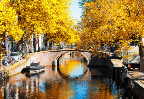 bridge of Amsterdam over canal ring landmark in old european citye, Holland Netherlands. Amsterdam fall scenery with tree lush. photo