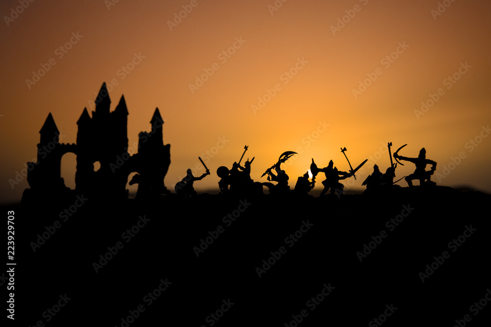 Medieval battle scene with cavalry and infantry. Silhouettes of figures as separate objects, fight between warriors on sunset foggy background. Medieval battle scene with cavalry and infantry. Silhouettes of figures as separate objects, fight between warriors on sunset foggy background.