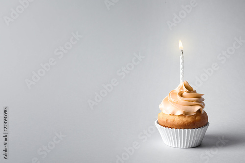 Canvas Print Delicious birthday cupcake with candle and space for text on gray background