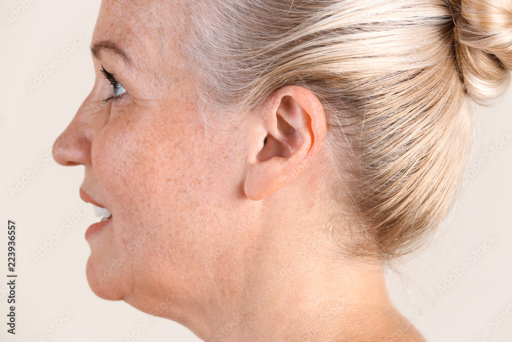 Naklejka premium Mature woman on light background, closeup. Hearing problem