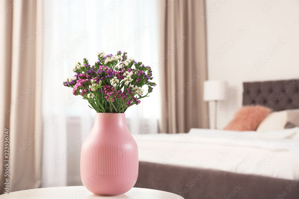 Beautiful flowers in vase and space for text on blurred background. Element of interior design Beautiful flowers in vase and space for text on blurred background. Element of interior design