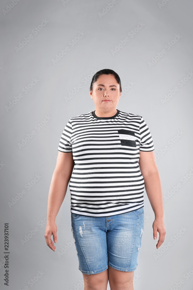 Obraz premium Fat woman on grey background. Weight loss