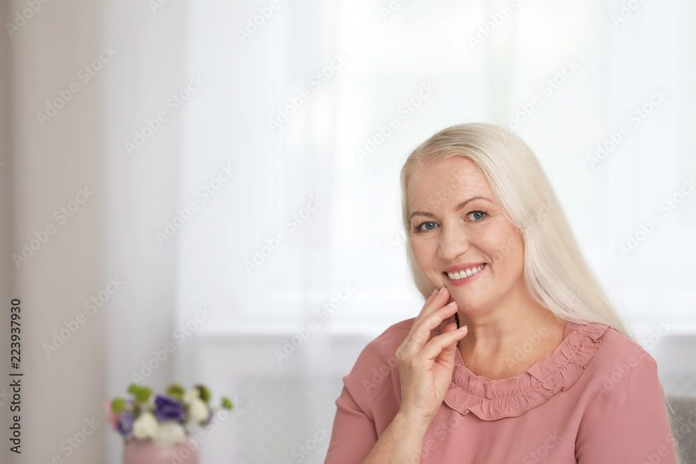 Portrait of beautiful older woman against blurred background with space for text Portrait of beautiful older woman against blurred background with space for text