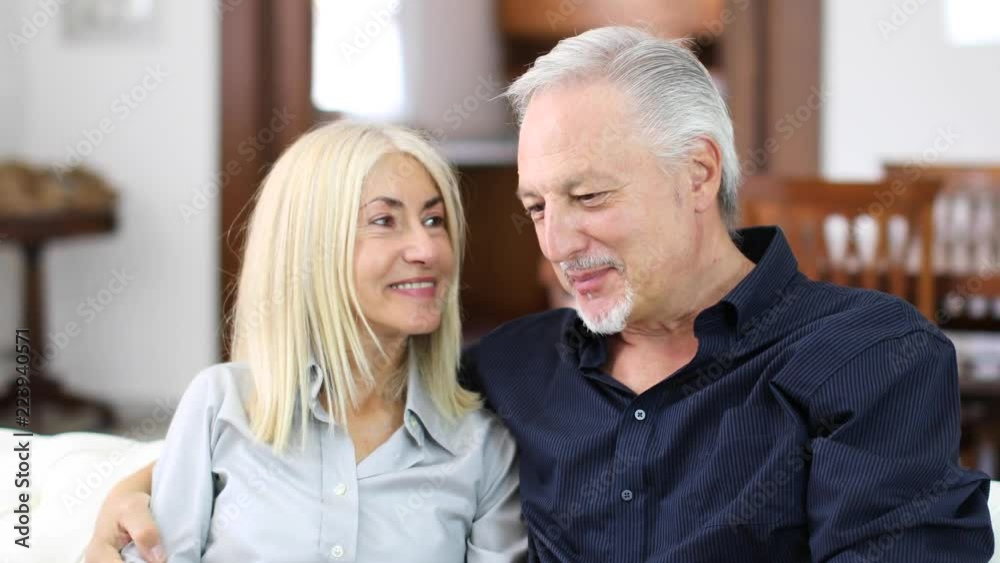 Senior relaxed couple on a sofa talking Senior relaxed couple on a sofa talking