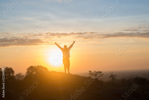 Happy young boy Enjoy Backpacking.Watch the first light of the morning sun on the mountain.Feel refreshed and energize your life.