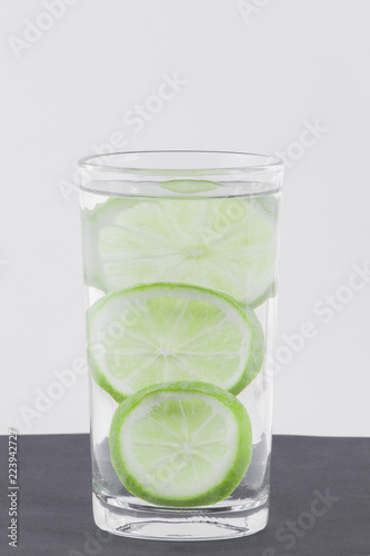 glass with water and lemon isolated on white background