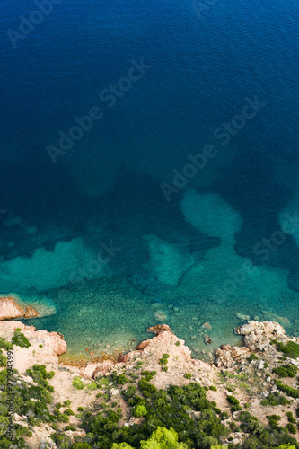 Spectacular aerial view of a beautiful wild and rocky coast bathed by a clear and turquoise sea, Sardinia, Italy.