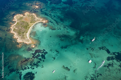 Fototapeta Naklejka Na Ścianę i Meble -  Spectacular aerial view of a little island bathed by a clear and turquoise sea, Sardinia, Italy.