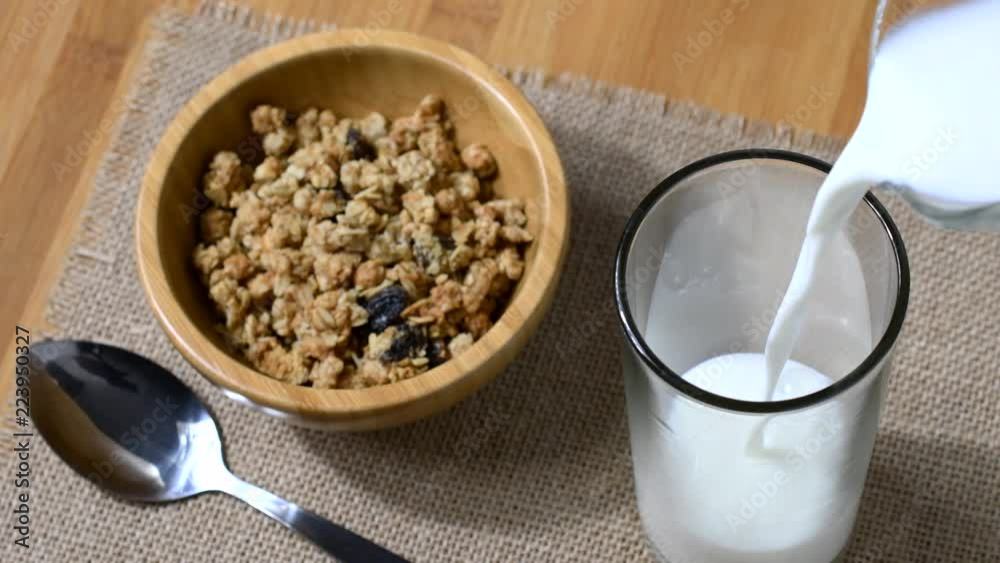 Pouring Milk in a glass (with Muesli in the background) Pouring Milk in a glass (with Muesli in the background)