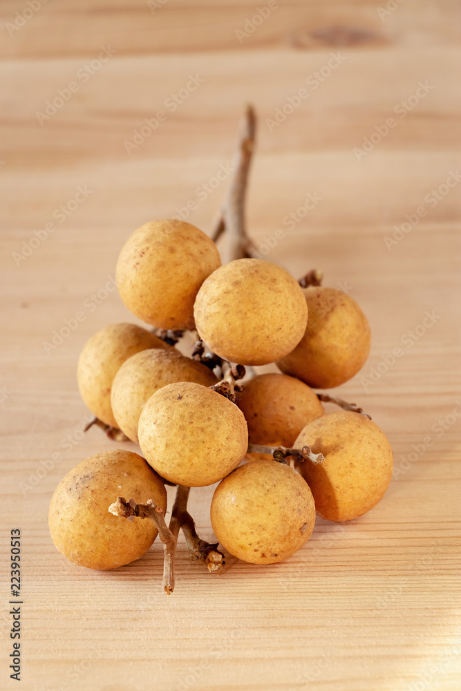 Bunch of tropical fruit Longan (Dimocarpus Longan). Wooden background. Bunch of tropical fruit Longan (Dimocarpus Longan). Wooden background.