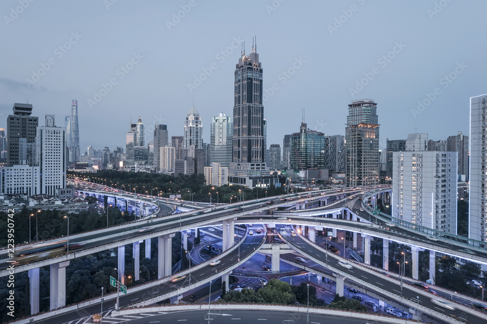 aerial view of buildings and highway interchange at dusk in Shanghai city