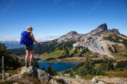 Obraz na plátne Adventurous girl enjoying the beautiful Canadian Mountain Landscape during a vibrant summer day