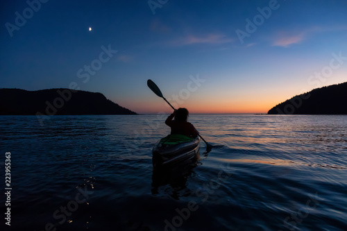 Sea Kayaking in the Pacific Ocean during twilight after summer sunset. Taken in San Josef Bay, Vancouver Island, BC, Canada.