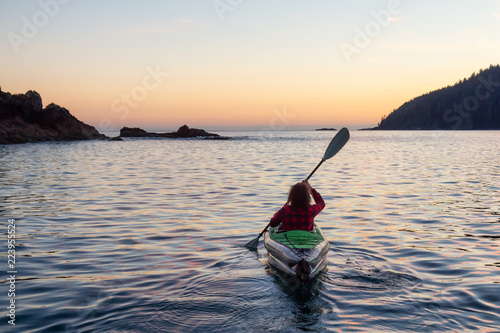 Girl kayaking in the Pacific Ocean during a cloudy summer sunset. Taken in San Josef Bay, Cape Scott, Northern Vancouver Island, BC, Canada. © edb3_16