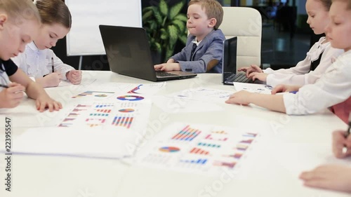 Young Children Sitting At Laptops In The Office
