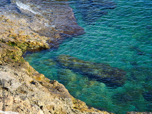 Big rocks by clear deep blue sea ocean Costa Blanca Spain