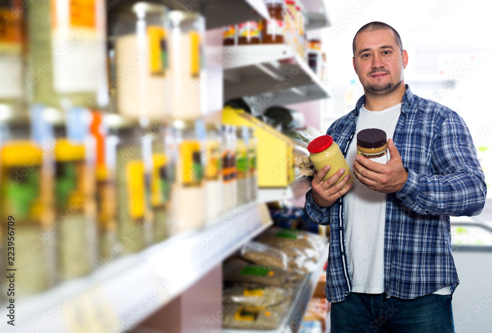 Man purchasing peanut butter in grocery