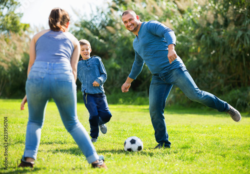 Portrait of active family playing soccer