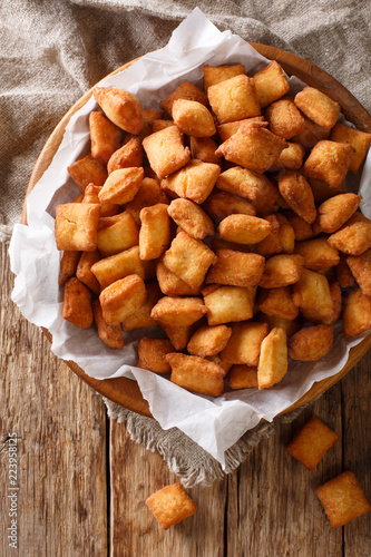West African popular food: appetizer Chin Chin fried crispy dough close-up in a bowl. Vertical top view