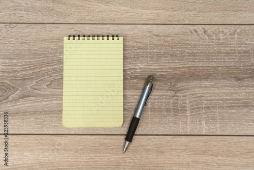 an empty block and a pen on the wooden table