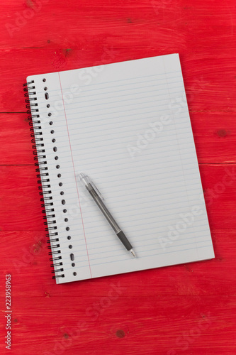 Notepad on a red wooden table © venemama