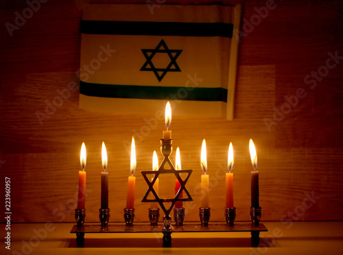Hanukkah is a Jewish holiday. Burning Chanukah candlestick with candles. Chanukiah Menorah. Flag of Israel photo