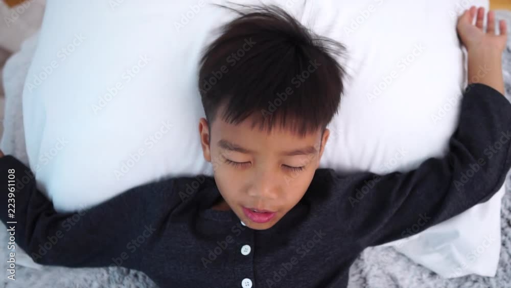 Slow motion of young Asian boy lay on a white bed Slow motion of young Asian boy lay on a white bed