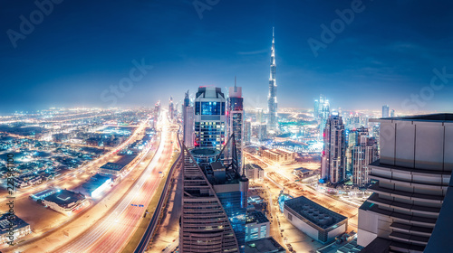 Spektakularna miejska panorama z kolorowymi iluminacjami miasta. Widok z lotu ptaka na autostradach i drapaczach chmur w Dubaju, Zjednoczone Emiraty Arabskie.