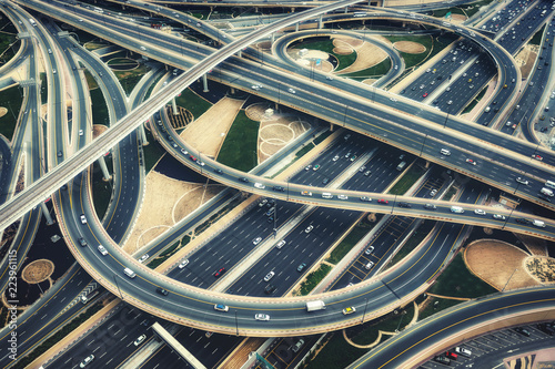 Aerial view of big highway interchange with traffic in Dubai, UAE, at day. Scenic cityscape. Colorful transportation, communications and driving background.